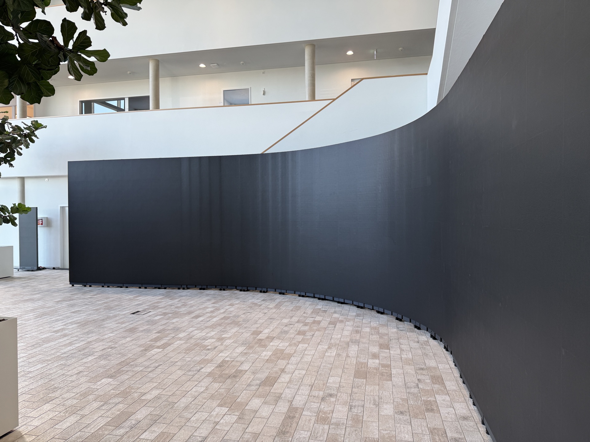 Gebogene LED-Wand in einem Foyer, der Gebäuderundung folgend aufgebaut