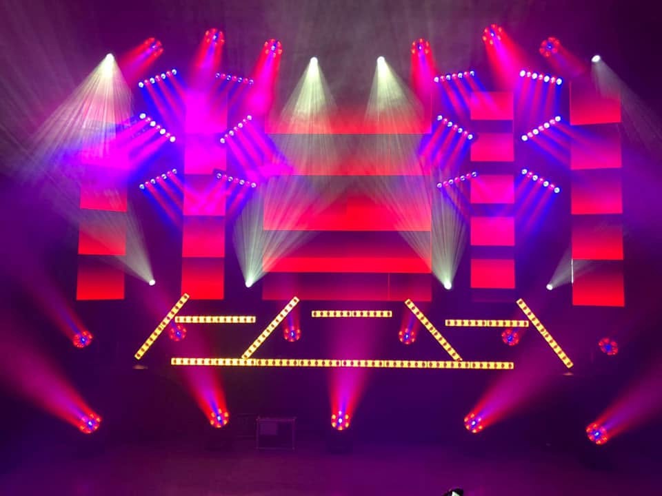 Lichtshow mit magentafarbenen Lichtstrahlen und LED-Leisten auf einer leeren Bühne
