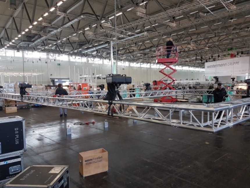 Traversenaufbau in einer Halle mit Scherenbühne und Flightcases