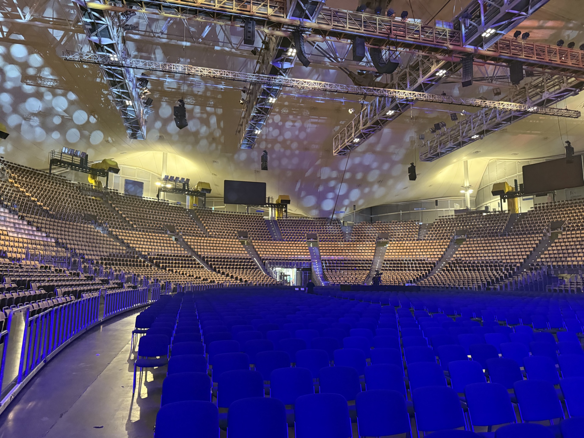 Arena vor der Veranstaltung mit hängenden Traversen über leerer Bestuhlung